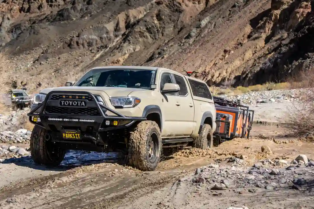 Toyota Tacoma towing an OPUS OP4 over rocky ground on the Mojave Road