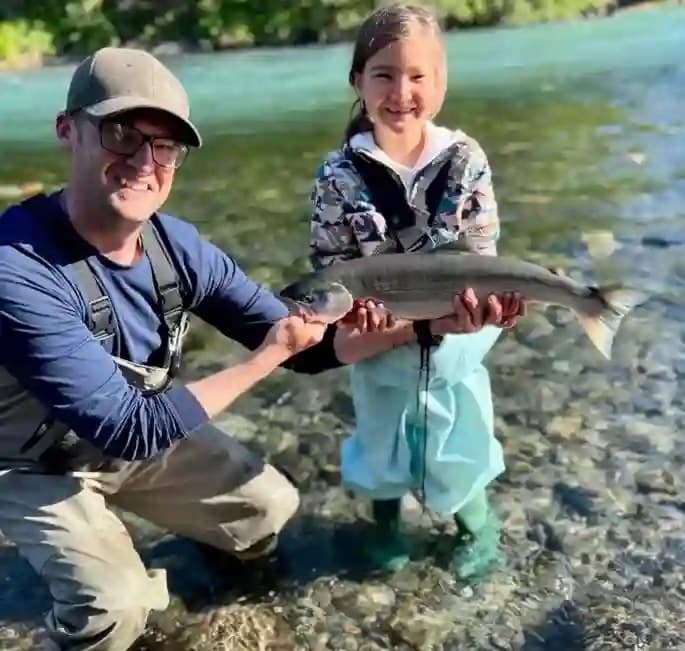 Father and daughter holding a salmon on a Kodiak fishing trip