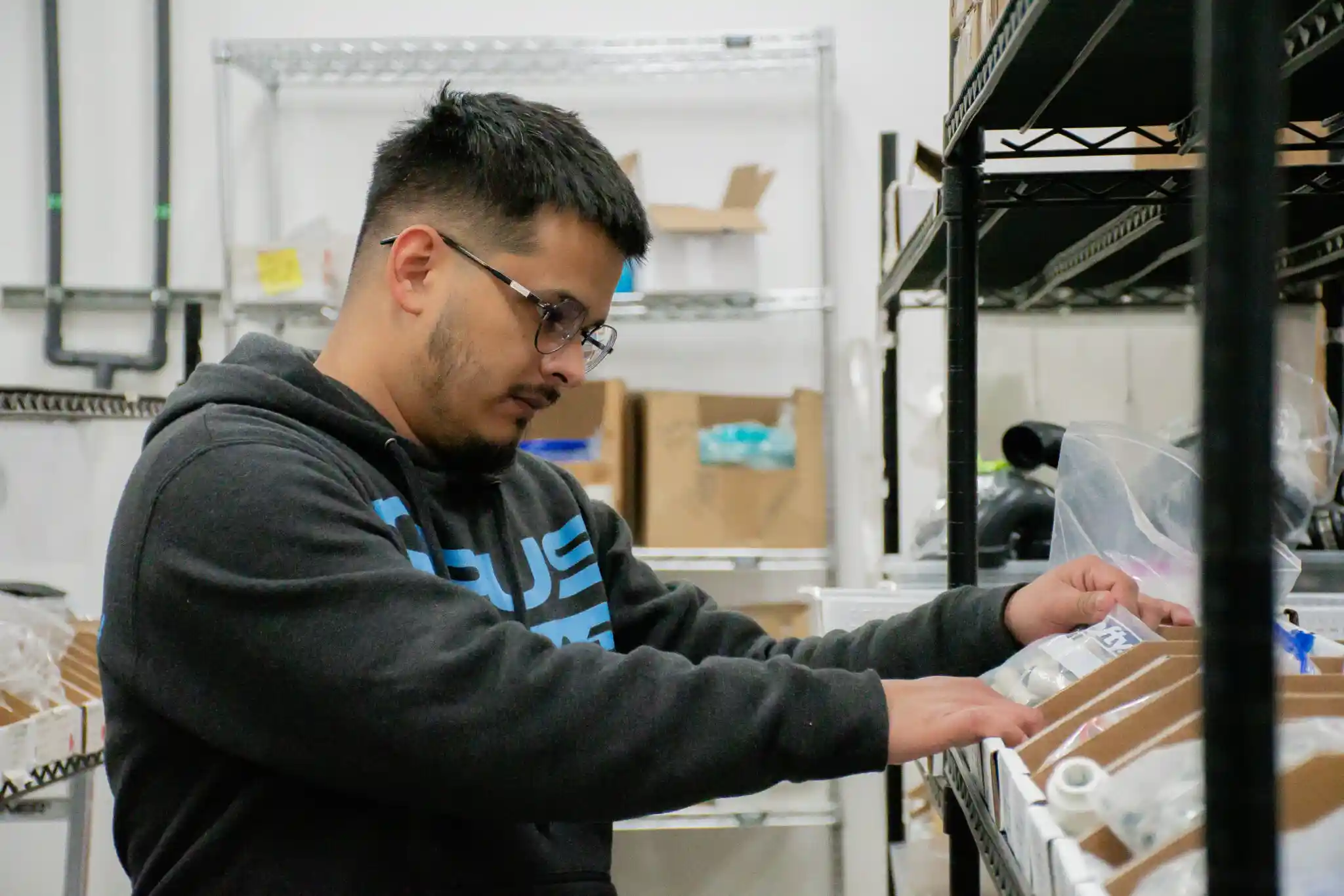 An OPUS team member picking components from the parts store shelving