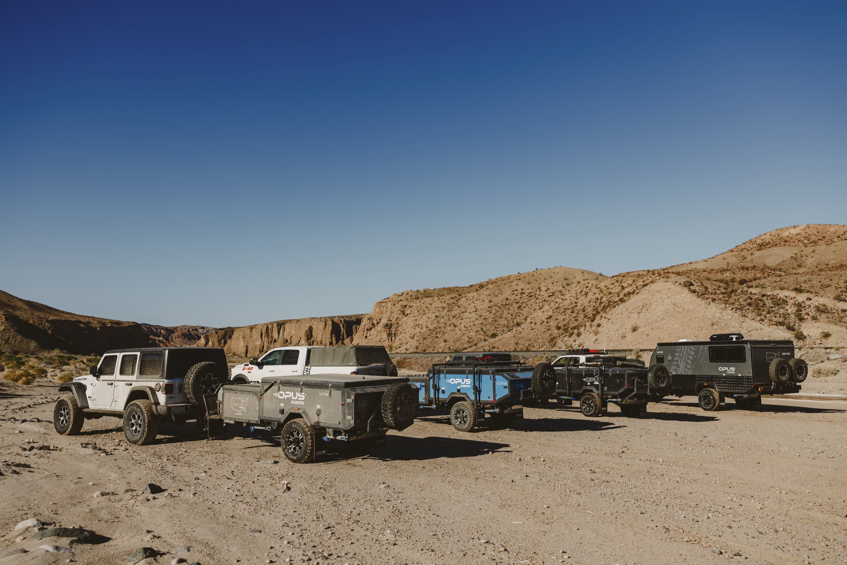 A convoy of OPUS campers on a desert track