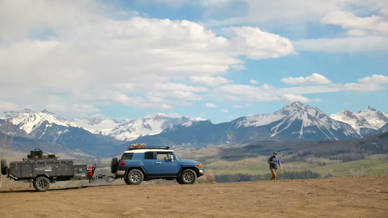 An OPUS camper trailer hitched up below the San Juan Mountains, Colorado