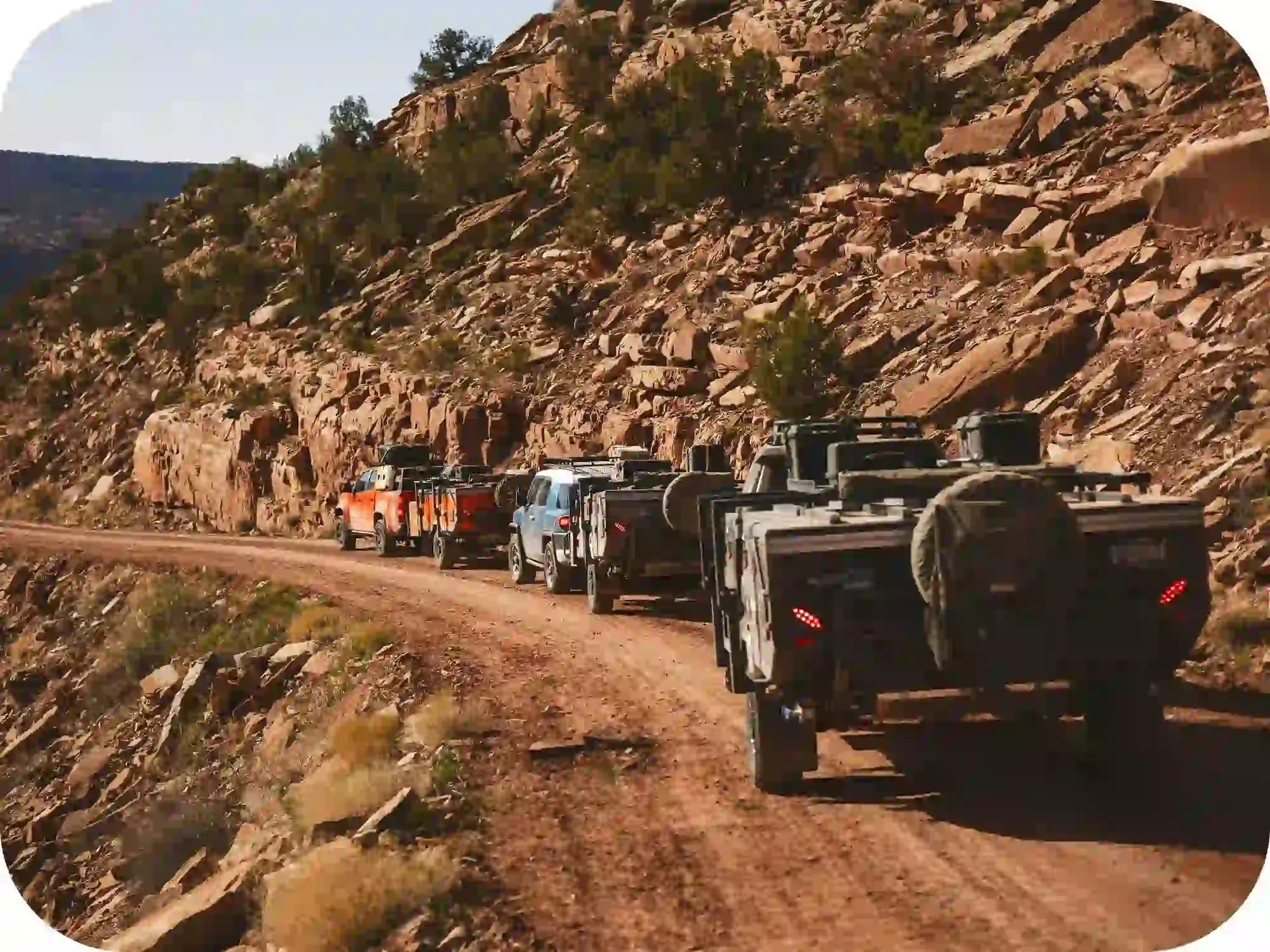OPUS camper off road convoy driving through rocky desert trail